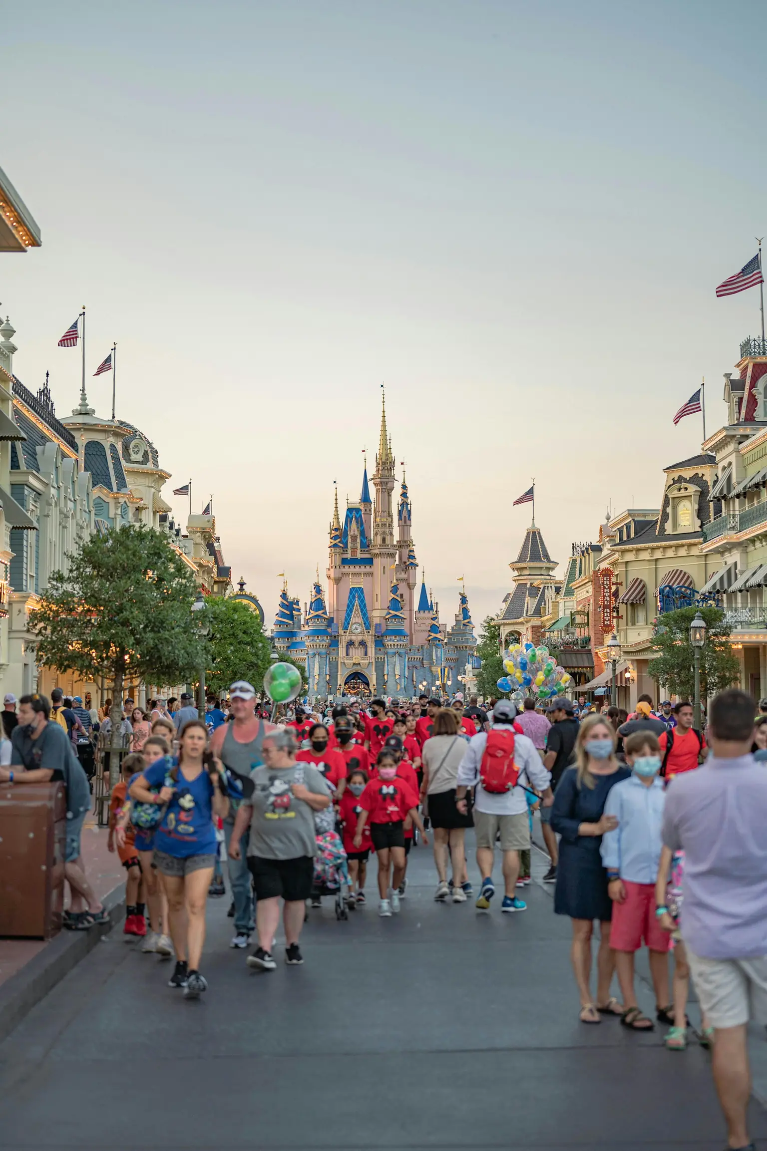 Families walking down Main Street, U.S.A. toward Cinderella Castle at Magic Kingdom