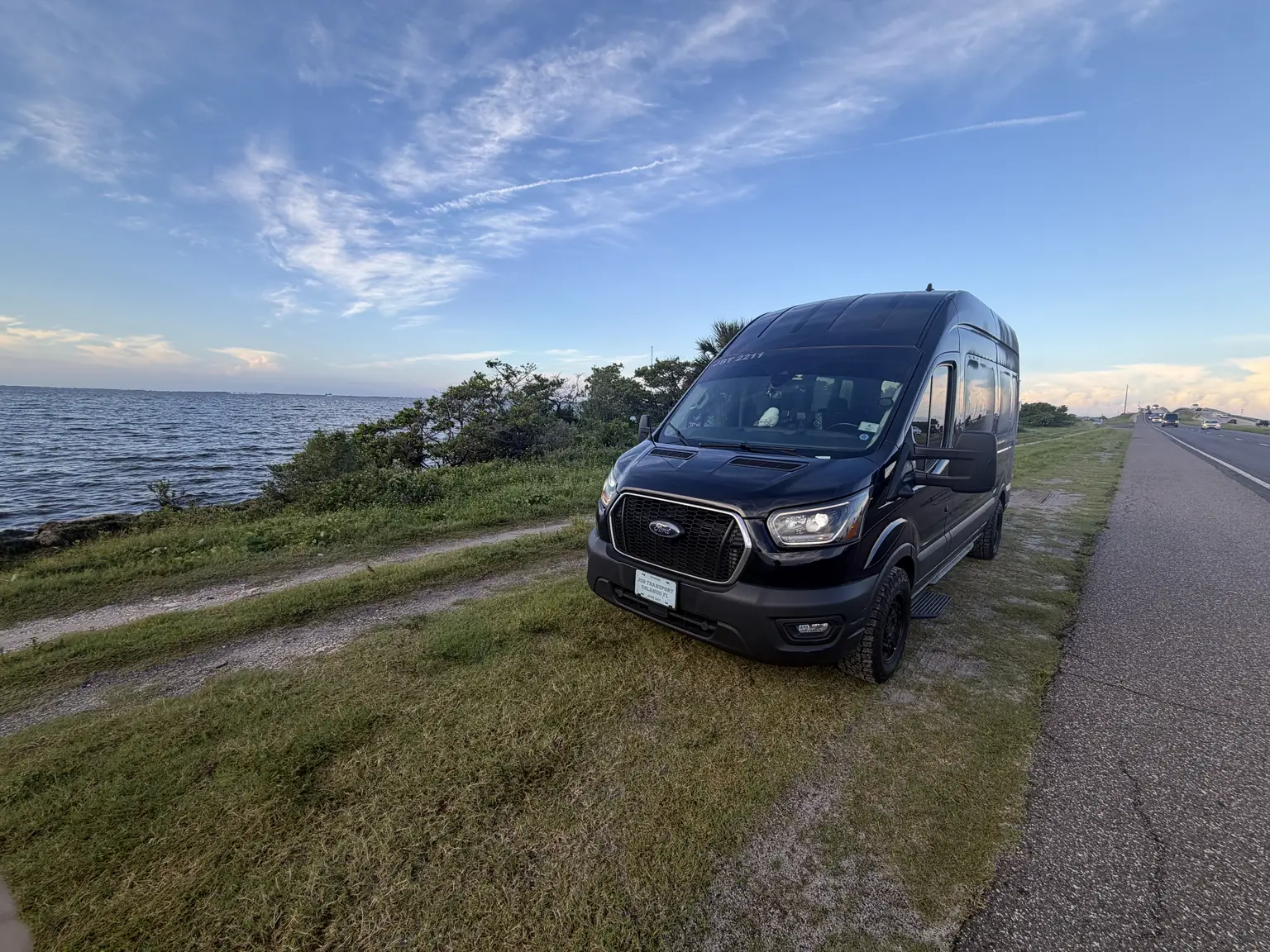 JOB's black Ford Transit van parked beside the water on a Space Coast causeway